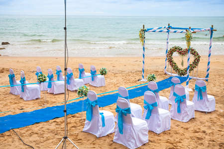 Beach wedding decorations . Interior colors blue sea . Blue drape Chair Cover , white and blue silk tie and a beautiful flower . Located on a quiet beach curves . A small beach in the south of Thailand.の写真素材