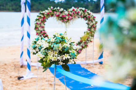 Beach wedding decorations . Interior colors blue sea . Blue drape Chair Cover , white and blue silk tie and a beautiful flower . Located on a quiet beach curves . A small beach in the south of Thailand.の写真素材