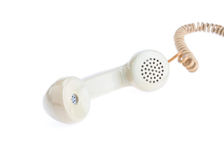 handset of antique telephone placed on isolate white background beside telephone machineの写真素材