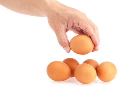 Hand pick up egg from white backgroundの写真素材