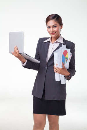 Business woman using laptop and hold files in another hand, smiling face. Shot in white backgroundの写真素材