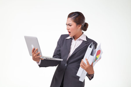 Business woman using laptop and hold files in another hand, working hard. Shot in white backgroundの写真素材
