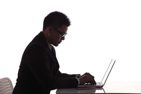 silhouette side view businessman use laptop computer on tableの写真素材