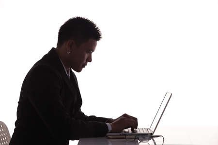 silhouette side view businessman use laptop computer on tableの写真素材