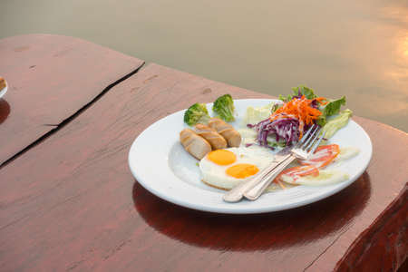 Breakfast plate on wooden table at terrace in the morning.の写真素材