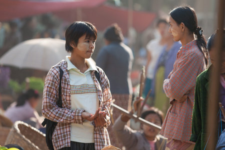 Bagan, Myanmar - January 25, 2009: Young teen using Tanaka face powder. Bagan, Myanmar.のeditorial素材