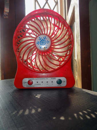 A small hand fan at the home on the tableの写真素材