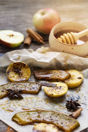 Healthy food concept with copy space. Autumn composition with sun light effect. baked spicy pumpkin with apples and cinnamon. Thanksgiving concept. Natural healthy food. Roasted pumpkin slices with spices and organic brown sugar.の写真素材