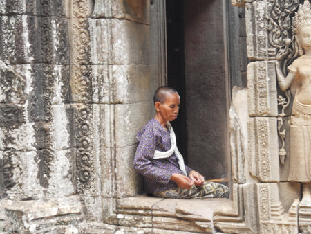 SIEM REAP, CAMBODIA - APRIL20 , 2013: A buddhist nun sit in Bayon temple on April 20,2013 in Siem Reap, Cambodiaのeditorial素材