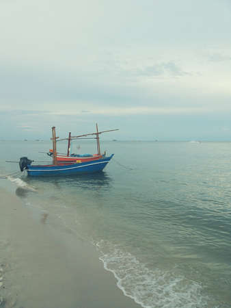 Small blue fishing boat moored at the beachの写真素材