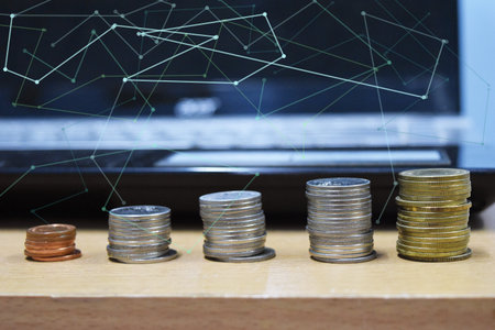 Four stacks coins row with computer laptop and Line symbols social network.in the background,...