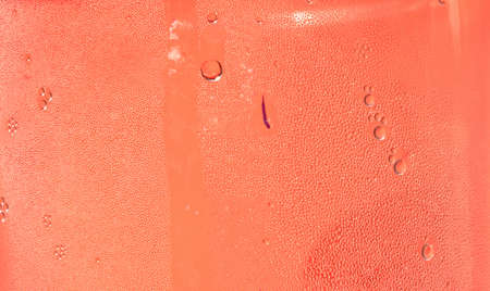 Droplets on object cool , Many water drops on the surface of a transparent plastic bottle on red background,Abstract Texture for add text or graphic designの写真素材