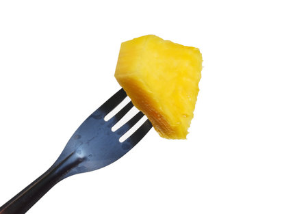 One piece of yellow pineapple fruit on a fork isolated on white background