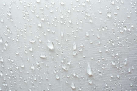 Water droplets on white textile, Moist rain drops on the surface of the umbrellaの写真素材