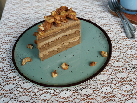 Coffee cashew nut layer cake and brown cream in a blue round dishの写真素材