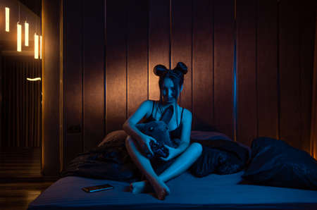 a girl with a pikachu toy plays a video game consoleの写真素材