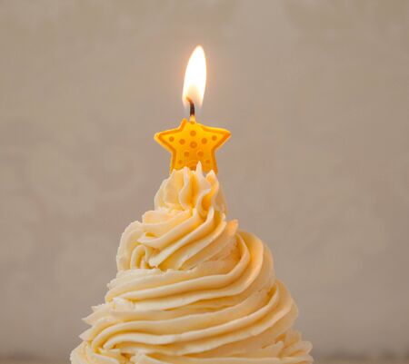 vanilla cream cupcake with birthday candle light starの写真素材