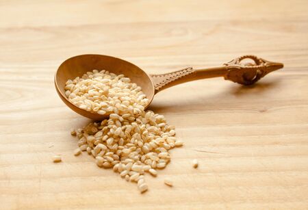 old wooden spoon and wheat seeds in cooking wood tableの写真素材