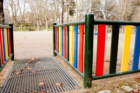 kids playground fence entrance with park trees backgroundの写真素材