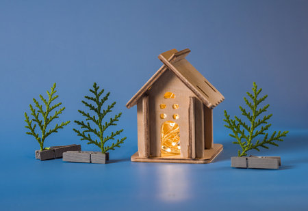 small homemade wooden house with a garland inside and a Christmas treeの写真素材