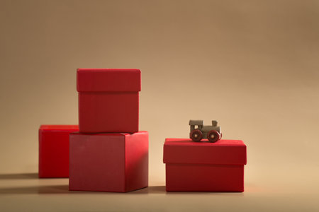 small wooden train with red gift boxes in a row on a beige backgroundの写真素材