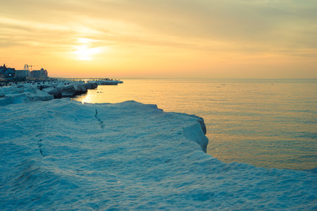 Blocks of ice on the seashore at sunsetの写真素材
