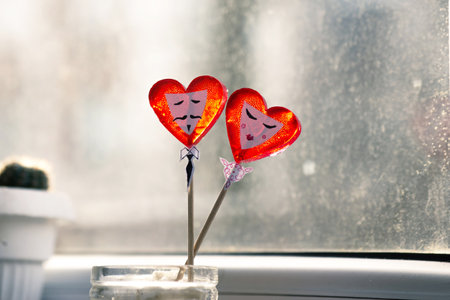 Two red hearts in a vase on the background of the windowの写真素材