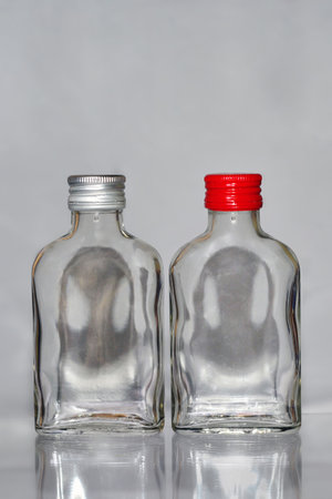 two empty glass bottles on a gray background, closeup of photoの写真素材