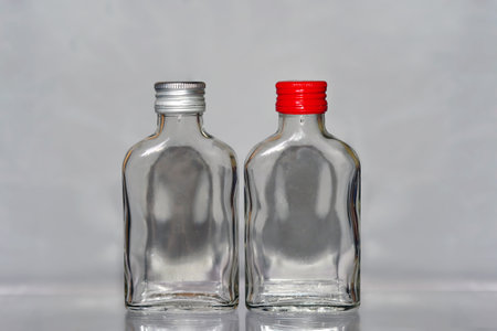 two empty glass bottles on a gray background, shallow depth of fieldの写真素材