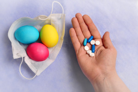 Pills and tablets in the hands of a woman on a blue background.の写真素材