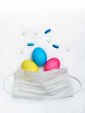 Colorful Easter eggs and medical mask on white background. Happy Easter concept.の写真素材