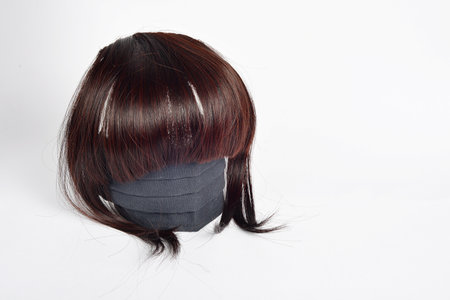 closeup of a woman's hair with a black mask on white backgroundの写真素材