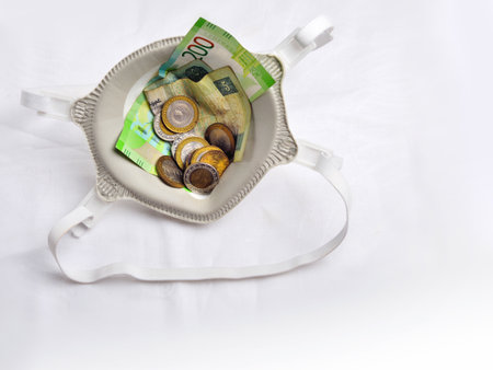 Euro banknotes and coins in a silver purse on a white backgroundの写真素材