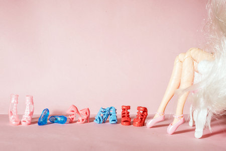 Doll legs with a row of toy shoesの写真素材