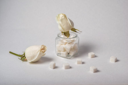 Sugar cubes and white roses on white background. selective focus.の写真素材