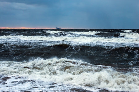 Stormy Baltic sea at sunset. Dramatic sky, stormy waves.の写真素材