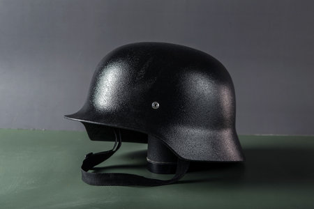 Black german helmet on a green background. side view. copyspace.の写真素材