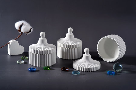 A still life of three white plaster home decor cups on a gray backgroundの写真素材