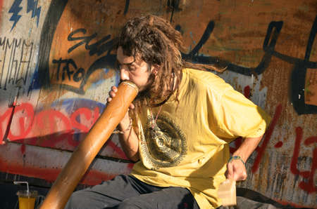 Turkey, Istanbul September 2013: Outdoor performance at graffiti wall  on september 11 2013, musician plays didgeridoo in Istanbul street.のeditorial素材