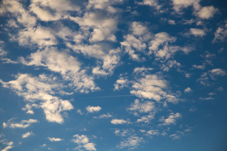 Beautiful blue sky with white fluffy clouds at sunset. Sky panorama for screensavers, postcards,...