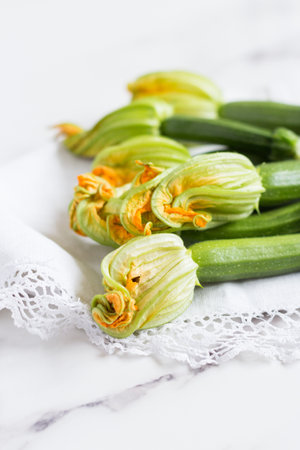 close-up view of zucchini flower on a white kitchen cloth lace, romantic buquetの写真素材