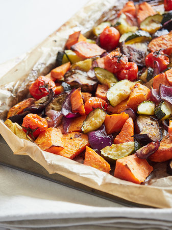 roasted vegetables pieces in a baking trayの写真素材