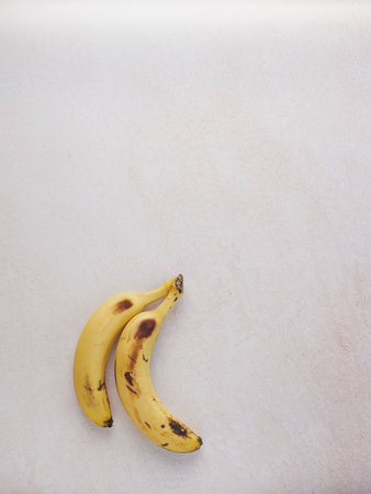overhead view of two isolated ripe bananas on pink background, copy spaceの写真素材