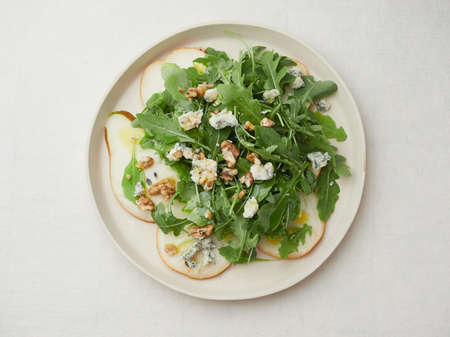 top view isolated plate of salad with arugula, pear, blue cheese and walnutsの写真素材