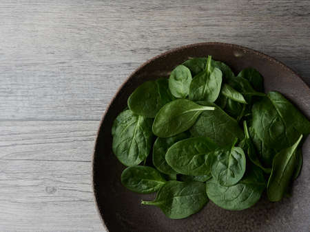 partial view of a plate with fresh spinach leaves ready for a salad. Isolated top view.の写真素材