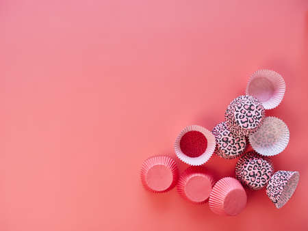 plain pink and leopard print pattern colored paper baking cups for cupcake and muffins. Top view on a pink background, space for copy.の写真素材