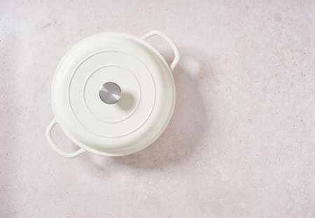 enameled cast iron pot, white cocotte new lidded isolated on pink stoneware background. Top view with copy space.の写真素材