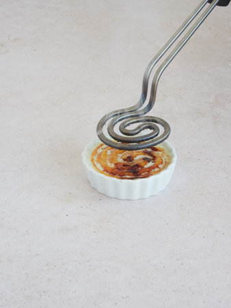 Electric caramelizing iron: hot spiral round iron utensil for caramelizing sugar.の写真素材