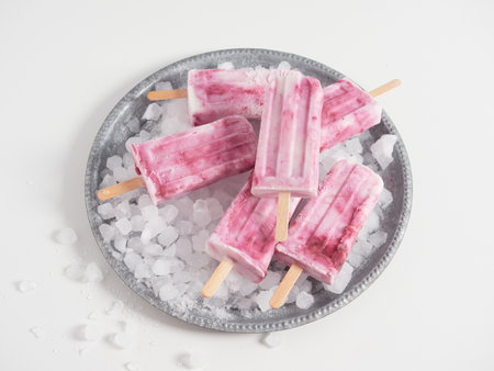 yogurt and strawberry homemade ice cream on ice in silver round trayの写真素材