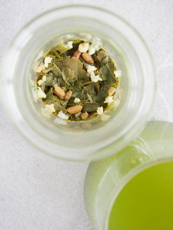 close-up view from above of green tea leaves and herbs infused in a glass cupの写真素材